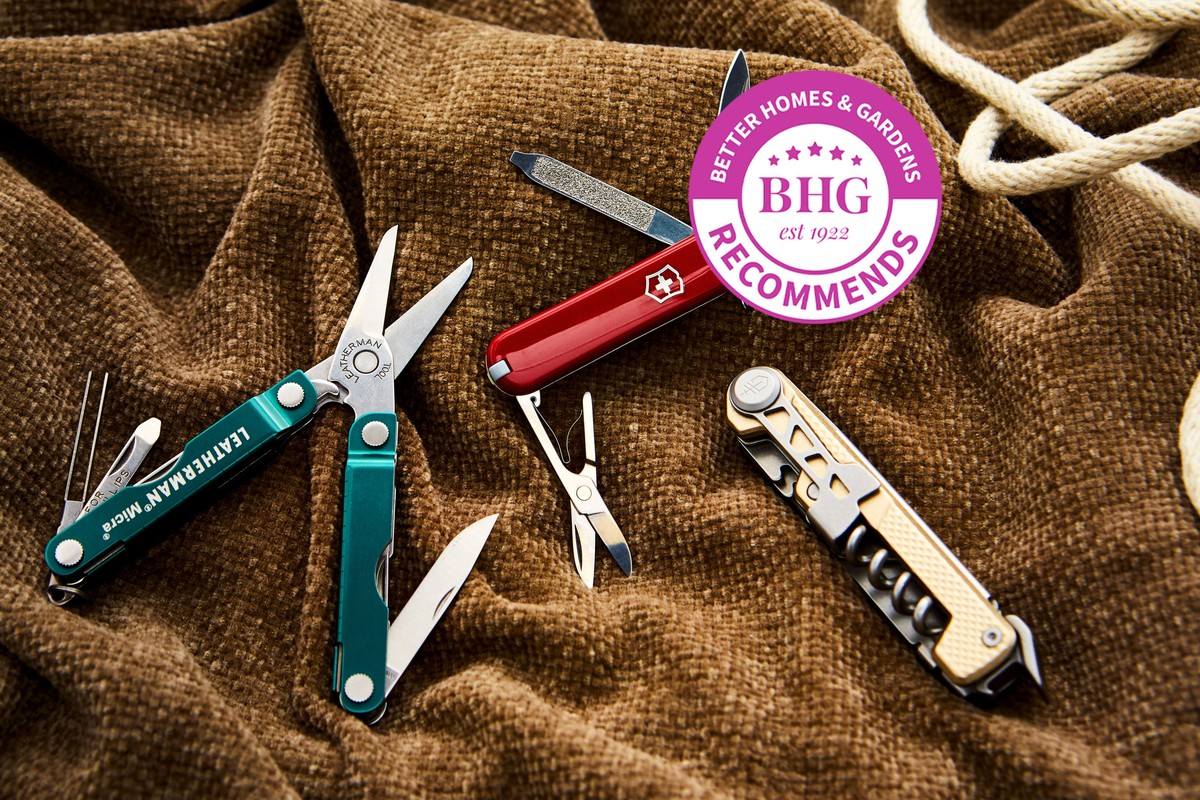 Various multi-tools displayed on a workbench for comparison